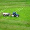 Tractor spreads fertilizer on a field
