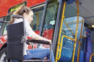 A lady in a wheel chair boarding a bus